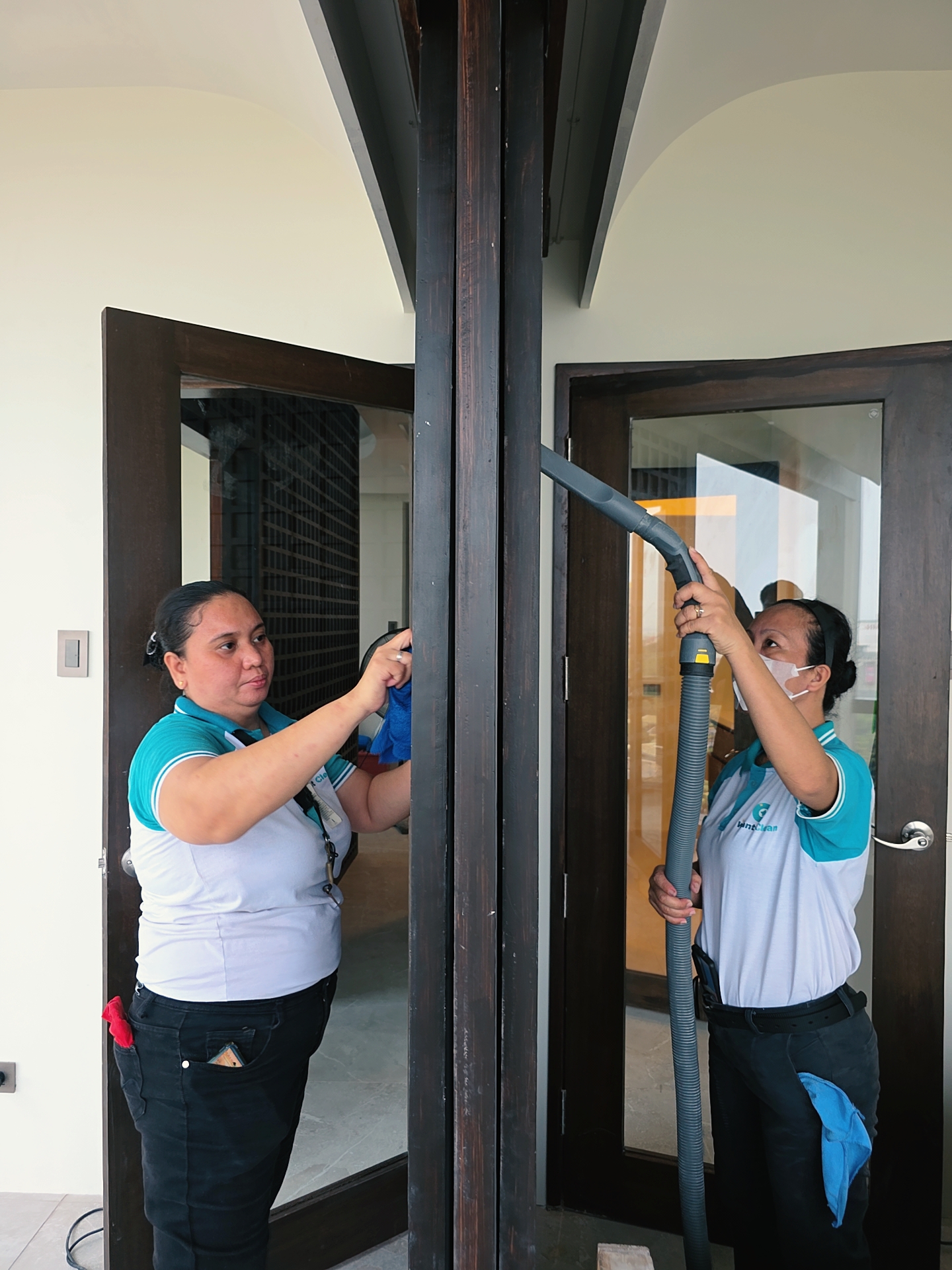 Technicians sanitizing glass doors with specialized equipment